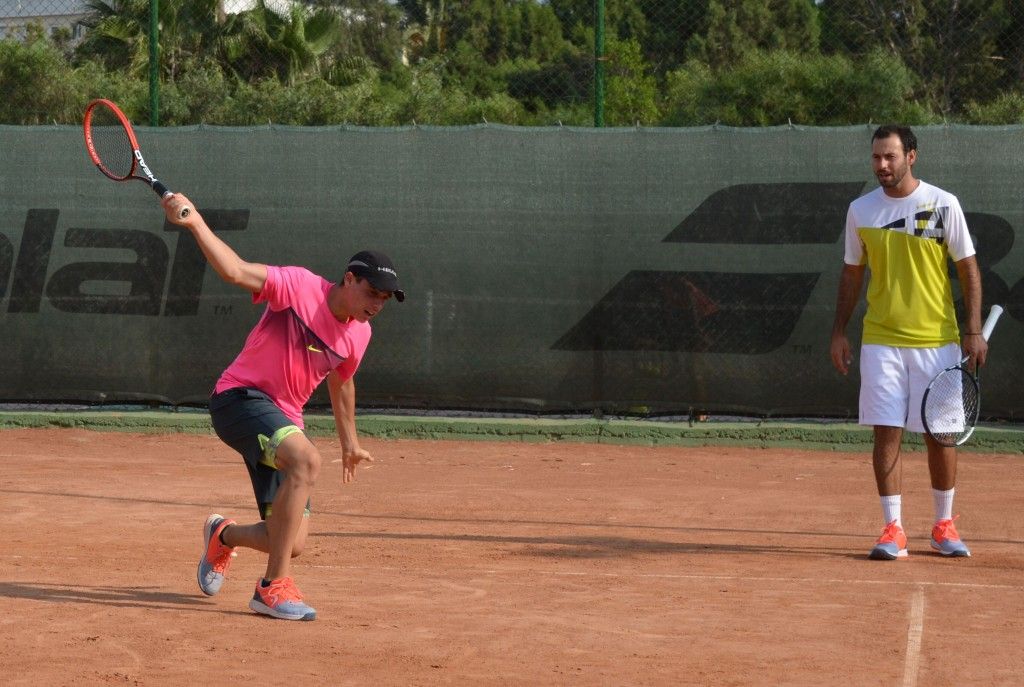 Teenage tennis players practicing on court